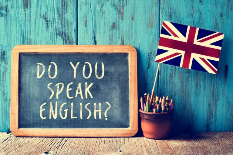 A blackboard with: 'Do you speak English?' written on it in white chalk, with a Union Jack next to it, so as to represent the English Language requirement for a UK visa.