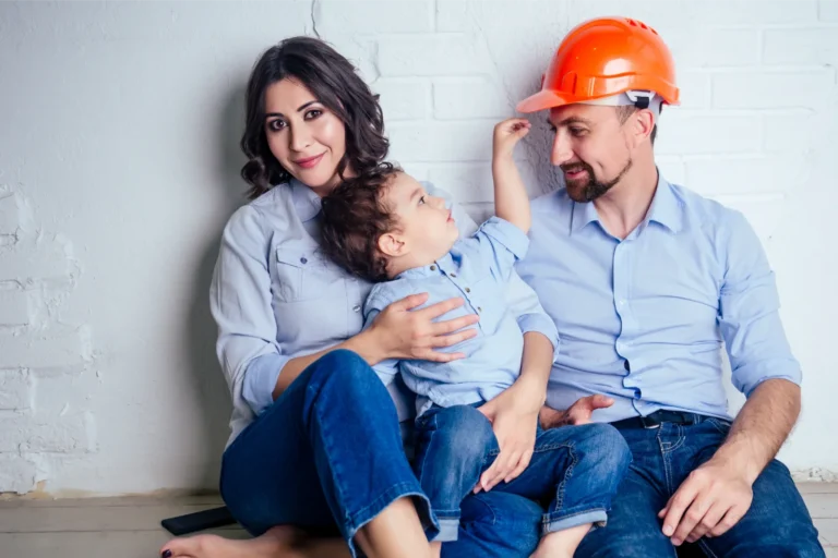 Man in a hardhat, his wife and his child pictured to represent coming to the UK with a Skilled Worker Dependant Visa.