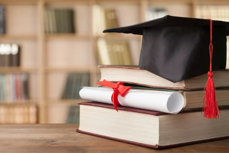 A university degree for proof of English in a library, on a table of books with a graduation cap